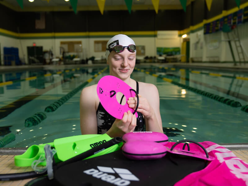 How to improve breaststroke time: swimmer holding a paddle