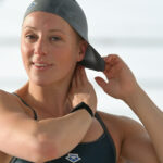 Swimmer fixing her hair into her swim cap