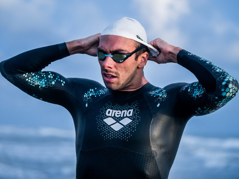 Hair care for swimmers: swimmer putting on a swim cap