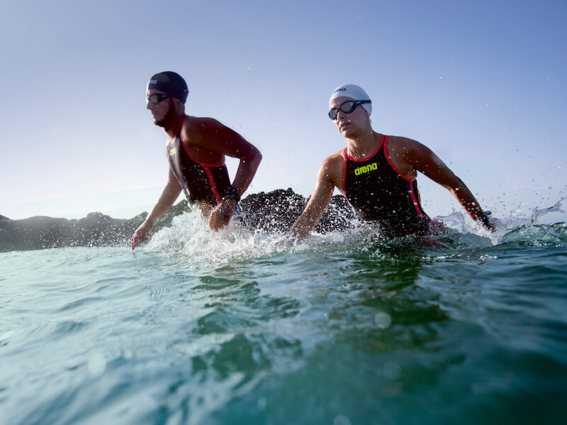 Swimmers in arena suit entering the ocean