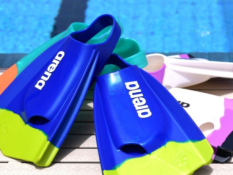 A collection of Arena swim fins poolside