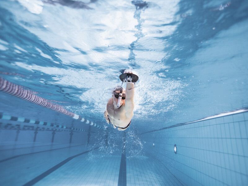 Swimmer using hand paddles