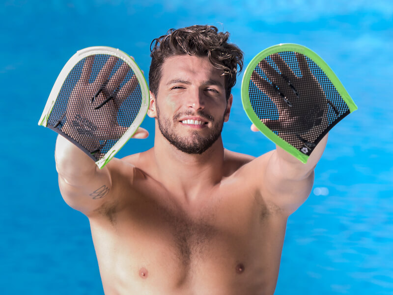 Swimmer showing his swimming hand paddles