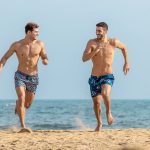 Men's beachwear: 2 men running on the shore
