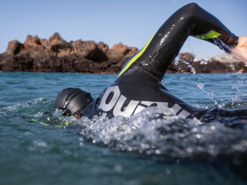 A swimmer wears Arena thermal swimwear in open water