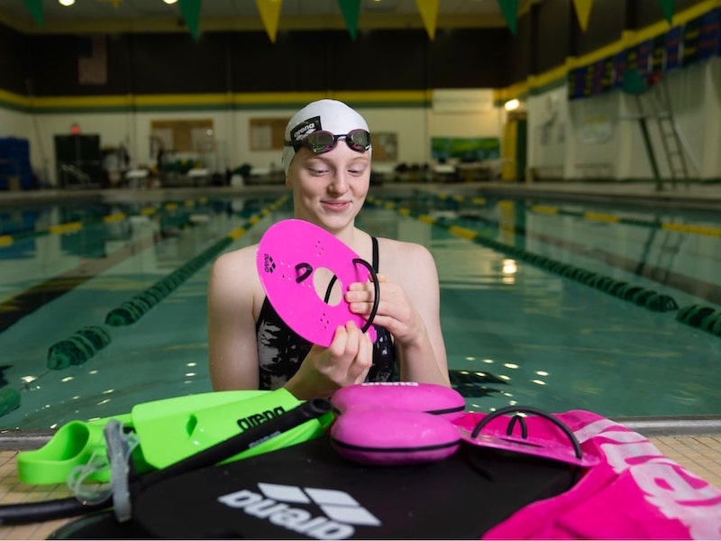 Swimming drills for beginners: swimmer arranging her swimming equipment