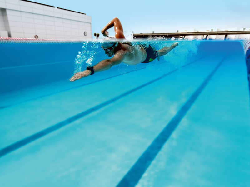 A person uses nose plugs for swimming laps in a pool