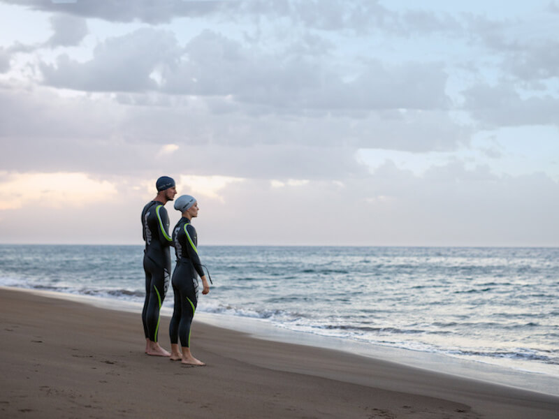 Two swimmers standing on a shore
