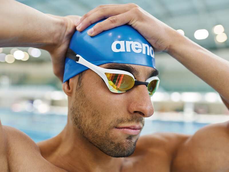 Swimmer fixing his Arena swim cap