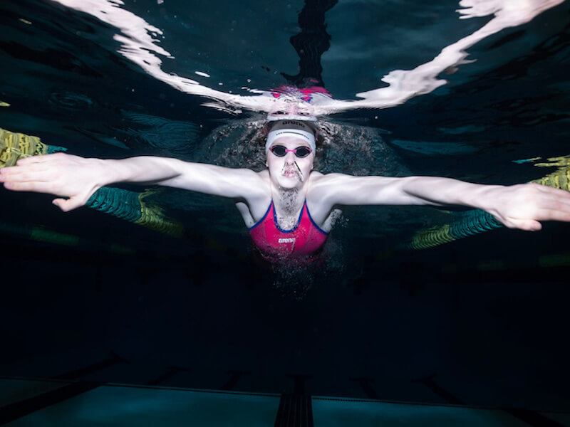 Swimmer's headache: A swimmer swims underwater with a swim cap and goggles 