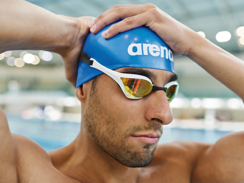 Swimmer's headache: A swimmer wears an arena swim cap and goggles
