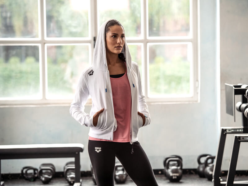 Core exercises for swimmers: woman wearing a hooded jacket while at the gym